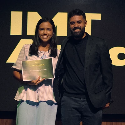 Aissa Alves da Silva Azevedo segura o certificado do Curso Cinegrafista ao lado de Israel Meira, na formatura de 09/09/2026