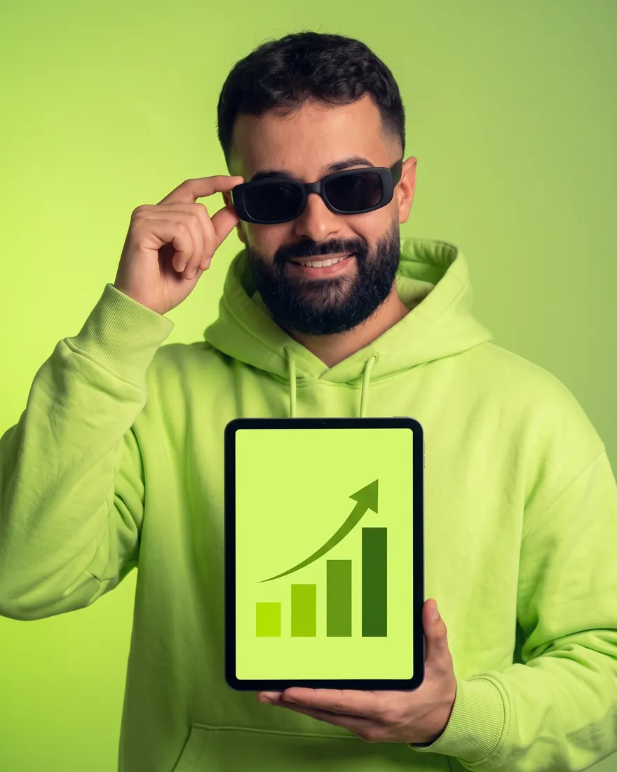 Israel Meira de moletom lime, sorrindo, com um tablet que mostra um gráfico subindo