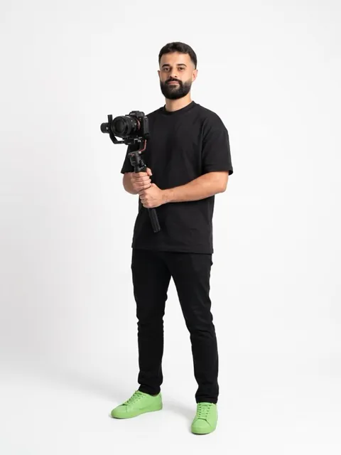 Exemplo de foto 3: Israel Meira de corpo inteiro, filmando com uma câmera num gimbal